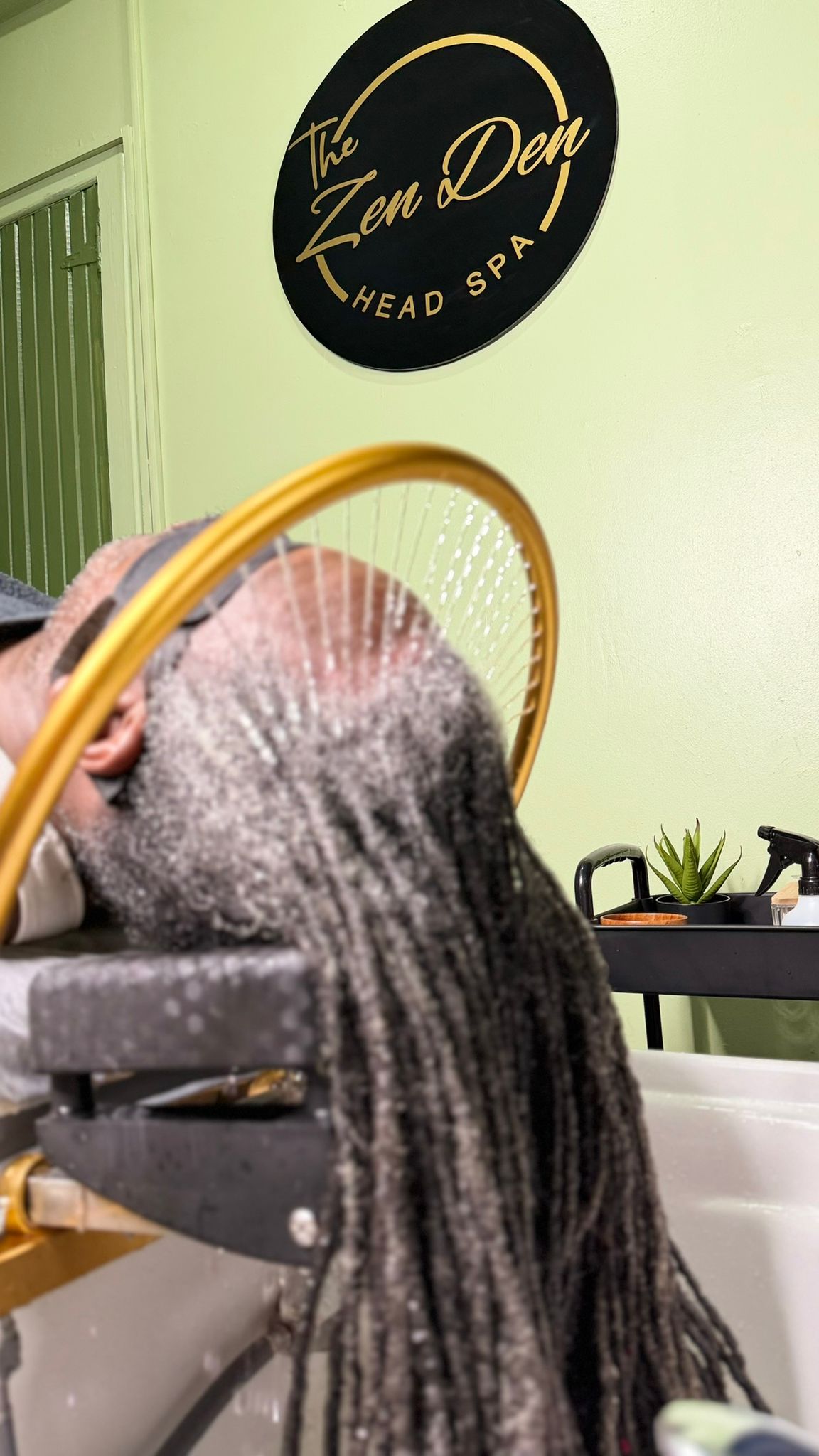 Zen Den therapist applying an ultrasound scalp device during a premium head spa ritual.